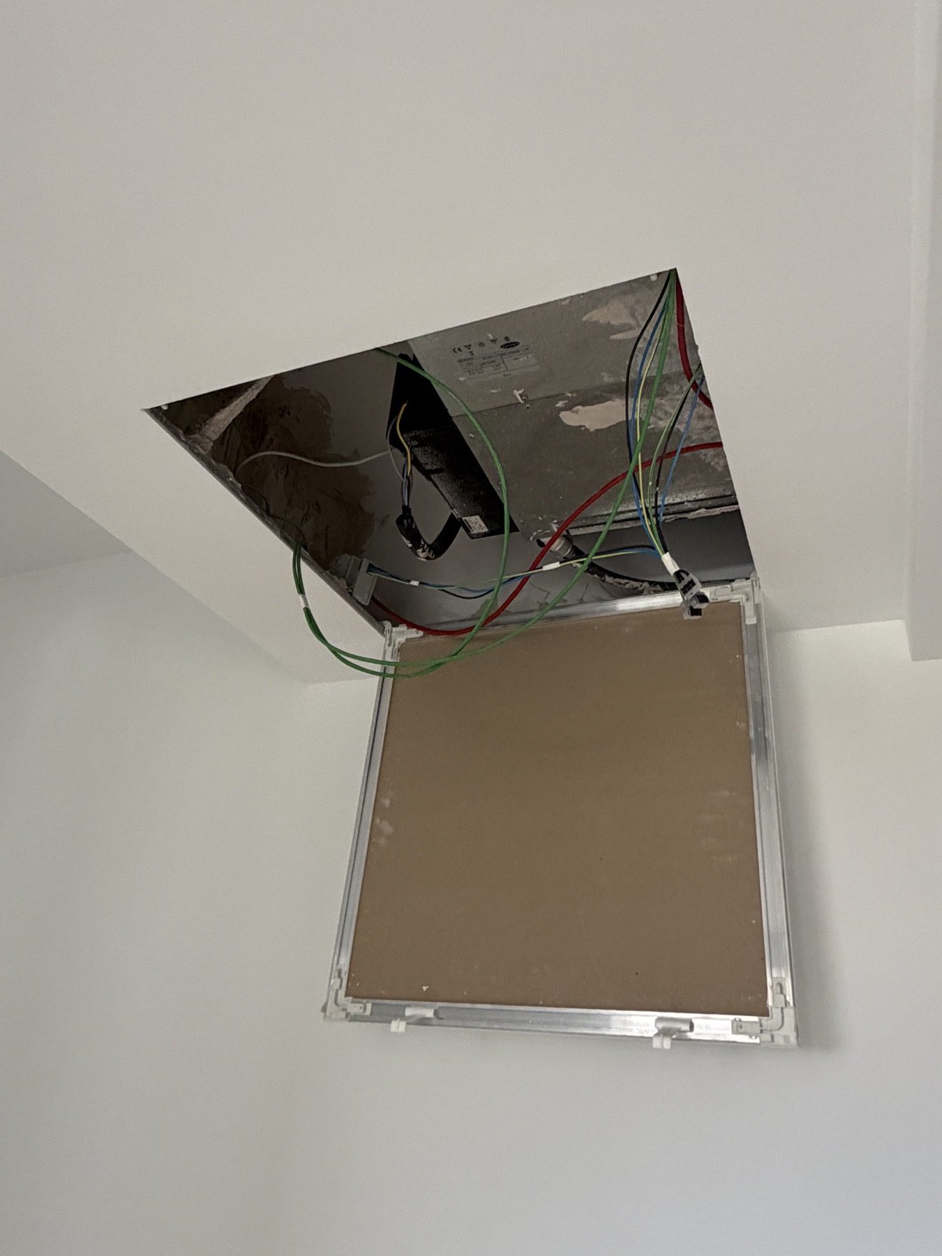 Open ceiling access with equipment and wiring exposed.