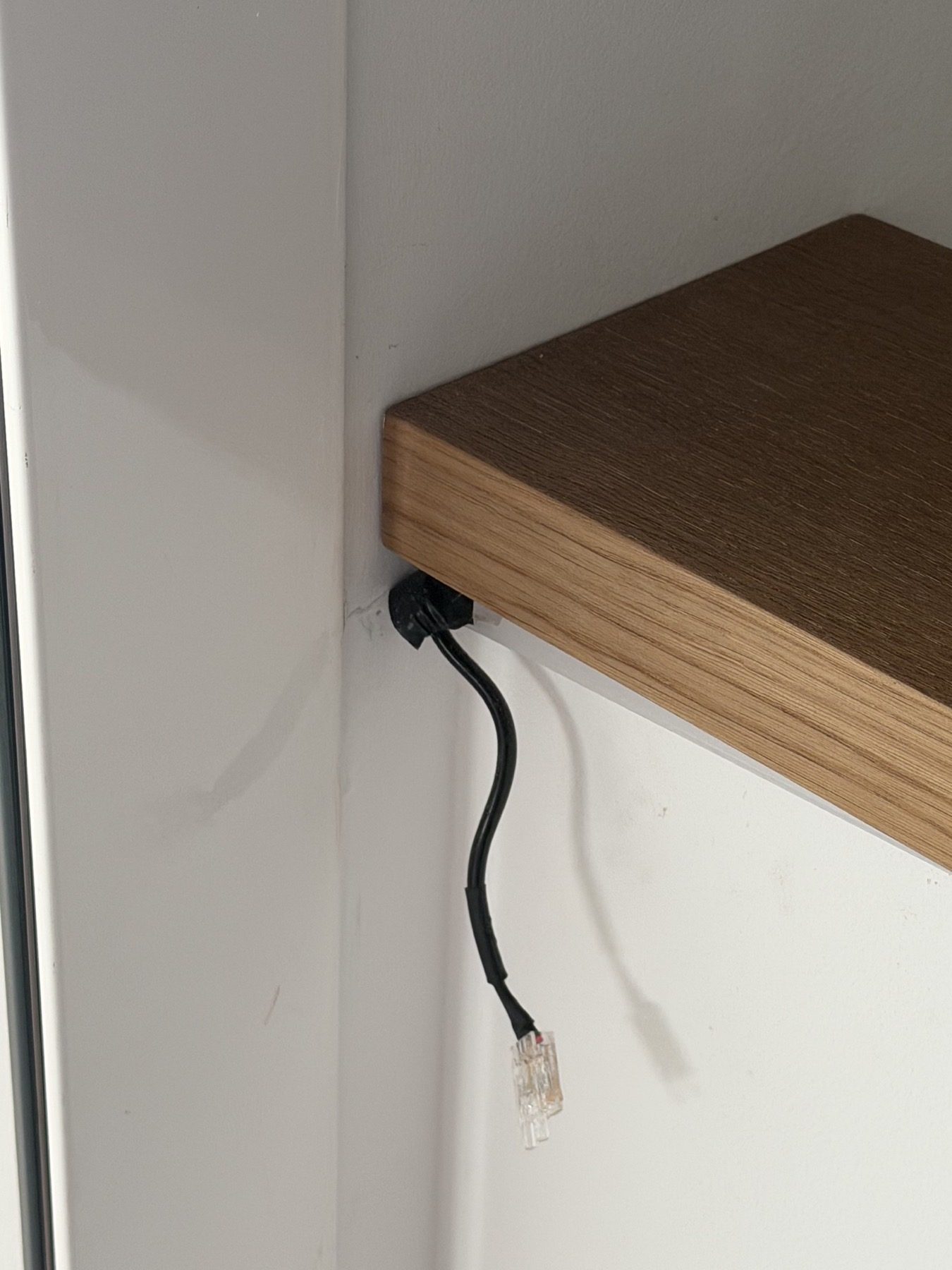 Loose cable left hanging below fitted joinery.