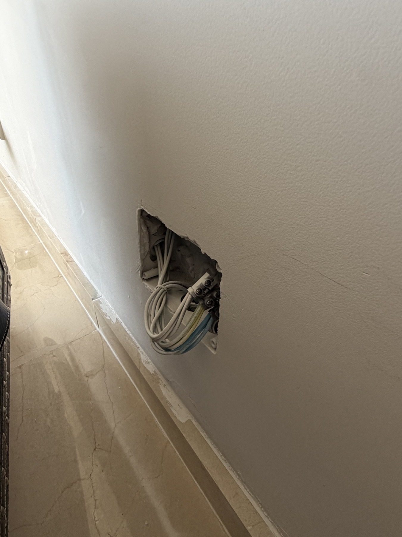 Open low-level electrical box with visible wiring and terminals.