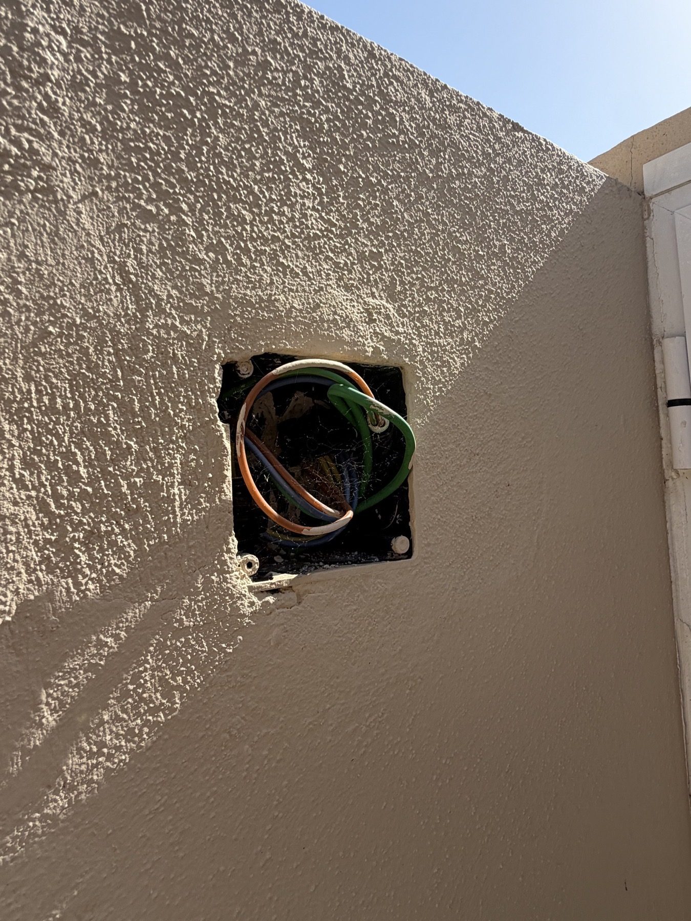 Close view of the uncovered exterior wiring.